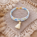 Bracelet tissu fleuri bleu avec pompon ivoire - Fait main